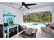 Enclosed outdoor patio featuring a pool with an inflatable shark, seating, and decorative nautical accents at 4509 95Th E Ter, Parrish, FL 34219