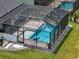 An aerial view features a screened-in pool with brick pavers and green landscaping at 4509 95Th E Ter, Parrish, FL 34219