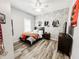 Bedroom features brick accent wall, wood floor, and ceiling fan at 4578 Cedar Brush Ter, Sarasota, FL 34243