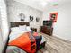 Bright bedroom features brick accent wall, ceiling fan, and wood floor at 4578 Cedar Brush Ter, Sarasota, FL 34243