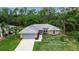 Lovely single-story home with a gray roof, attached garage, and lush green surroundings at 4673 Lummus St, North Port, FL 34286
