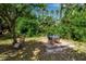Lush backyard with a cozy outdoor dining area and a relaxing lounge chair under a mature tree at 4673 Lummus St, North Port, FL 34286