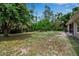 Expansive backyard surrounded by trees, featuring an outdoor seating area and space for recreation at 4673 Lummus St, North Port, FL 34286