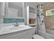 Bright bathroom with a tub-shower combination, white vanity, and stylish blue tile backsplash at 4673 Lummus St, North Port, FL 34286