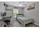 Bedroom with a fan, natural light, modern desk, and stylish decor create a cozy yet functional space at 4673 Lummus St, North Port, FL 34286
