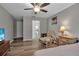 Comfortable bedroom with a bathroom entrance, chair, footrest, bedside table, and natural light at 4673 Lummus St, North Port, FL 34286
