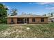 Back exterior of the house showcasing a screened-in patio and a spacious, well-maintained lawn at 4673 Lummus St, North Port, FL 34286