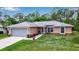 Charming single-story home with a well-kept lawn, two-car garage, and inviting front entrance at 4673 Lummus St, North Port, FL 34286