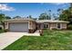 Charming single-Gathering home featuring a manicured lawn and a two-car garage on a sunny day at 4673 Lummus St, North Port, FL 34286