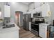 Modern kitchen featuring stainless steel appliances, white cabinetry, breakfast bar, and hardwood floors at 4673 Lummus St, North Port, FL 34286