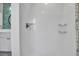 Bright shower features white tiling, inset shelves, and a showerhead with an adjacent modern bathroom at 4673 Lummus St, North Port, FL 34286