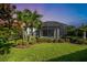 Landscaped backyard with lush green lawn and screened-in lanai at 4704 Stafford Ct, Palmetto, FL 34221