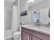 Well-lit bathroom with a combination shower and tub, vanity with granite counters and cabinet storage at 4704 Stafford Ct, Palmetto, FL 34221
