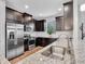 Modern kitchen featuring stainless steel appliances, granite countertops, and dark wood cabinetry at 4704 Stafford Ct, Palmetto, FL 34221