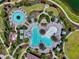 Aerial view of resort-style community pools with lush landscaping, lounge chairs, and umbrellas at 4704 Stafford Ct, Palmetto, FL 34221