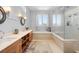 Bright bathroom features a soaking tub, glass shower, dual sinks, and ample counter space at 4964 Commonwealth Dr, Sarasota, FL 34242