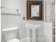 Bright bathroom features a pedestal sink, framed mirror, and white tiled shower at 4964 Commonwealth Dr, Sarasota, FL 34242