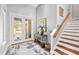 Elegant entryway featuring wood floors, staircase, and entryway with double glass doors at 4964 Commonwealth Dr, Sarasota, FL 34242