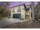 Elegant home at dusk featuring a two-car garage, balconies, and lush landscaping at 4964 Commonwealth Dr, Sarasota, FL 34242