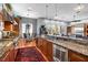 Open-concept kitchen showcasing stone counters, wooden cabinets, and seamless flow to the dining and living area at 4964 Commonwealth Dr, Sarasota, FL 34242