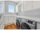 Modern laundry room features white cabinets, countertops, and stainless steel appliances at 4964 Commonwealth Dr, Sarasota, FL 34242