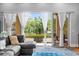 Bright living room with gray sectional couch, blue ottoman, and sliding glass doors to balcony at 4964 Commonwealth Dr, Sarasota, FL 34242