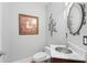 Stylish powder room with decorative mirror, updated fixtures, and ample lighting at 4964 Commonwealth Dr, Sarasota, FL 34242