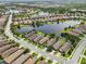 An expansive lake complements the single Gathering homes with barrel-tile roofs in this stunning aerial view at 5019 Serata Dr, Lakewood Ranch, FL 34211