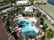 Aerial view of community pool with palm trees, lounge chairs, cabanas and surrounding lush landscaping at 5019 Serata Dr, Lakewood Ranch, FL 34211