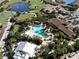 Overhead view of a resort-style pool, clubhouse, and golf course surrounded by lush tropical landscaping at 5019 Serata Dr, Lakewood Ranch, FL 34211