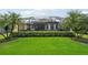 Expansive lawn and manicured landscaping surrounding a screened-in patio and pool area at 5019 Serata Dr, Lakewood Ranch, FL 34211
