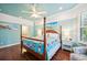 Cozy bedroom with a four-poster bed, hardwood floors, and a view into the attached bathroom at 5019 Serata Dr, Lakewood Ranch, FL 34211