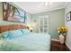 Cozy bedroom featuring a light blue comforter, ceiling fan, and tropical wall art at 5019 Serata Dr, Lakewood Ranch, FL 34211