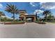Paver entryway with palms and flowers leading to a clubhouse, offering a grand welcome at 5019 Serata Dr, Lakewood Ranch, FL 34211