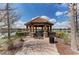 Lakeside gazebo with stone accents, seating, and a tile roof, perfect for relaxing by the water at 5019 Serata Dr, Lakewood Ranch, FL 34211