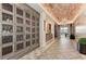 Hallway with wine storage, brick ceiling, patterned tile floor, and decorative lighting at 5019 Serata Dr, Lakewood Ranch, FL 34211