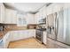 Well-lit kitchen featuring stainless steel appliances, granite countertops, and classic white cabinets at 5019 Serata Dr, Lakewood Ranch, FL 34211