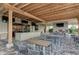 Community outdoor patio area with a stone fireplace and television at 5019 Serata Dr, Lakewood Ranch, FL 34211