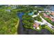 Aerial view showcases the community with tennis courts, waterways, lush landscaping, and single-Gathering homes at 5032 Timber Chase Way, Sarasota, FL 34238