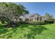 Beautiful backyard with a screened pool, lush green grass and manicured landscaping at 5032 Timber Chase Way, Sarasota, FL 34238