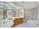 Bathroom featuring double sinks, vanity, tub, walk-in shower, and a ceiling fan at 5032 Timber Chase Way, Sarasota, FL 34238