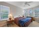 Bright bedroom with a ceiling fan, carpeted floors, and ample natural light from multiple windows at 5032 Timber Chase Way, Sarasota, FL 34238