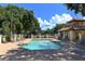 Community pool area with brick pavers, lounge chairs, and lush landscaping at 5032 Timber Chase Way, Sarasota, FL 34238