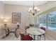 Charming dining area with glass table, chandelier, and view of the refreshing pool outside at 5032 Timber Chase Way, Sarasota, FL 34238