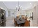 Open dining room with view to living area, featuring a dark wood table and rattan chairs at 5032 Timber Chase Way, Sarasota, FL 34238
