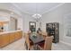 Elegant dining room with chandelier, dark wood table, six chairs, and view to the kitchen area at 5032 Timber Chase Way, Sarasota, FL 34238