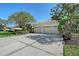 Spacious driveway leading to an attached two-car garage; the yard has mature trees and landscaping at 5032 Timber Chase Way, Sarasota, FL 34238