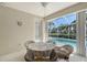 Enclosed patio with a table and chairs providing a serene view of the sparkling pool and lush greenery at 5032 Timber Chase Way, Sarasota, FL 34238