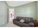 Green living room with couch, neutral carpet and a glimpse of other rooms beyond an open door at 5032 Timber Chase Way, Sarasota, FL 34238