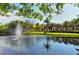 Picturesque pond view with a fountain, greenery, and a pergola-covered walkway at 5032 Timber Chase Way, Sarasota, FL 34238